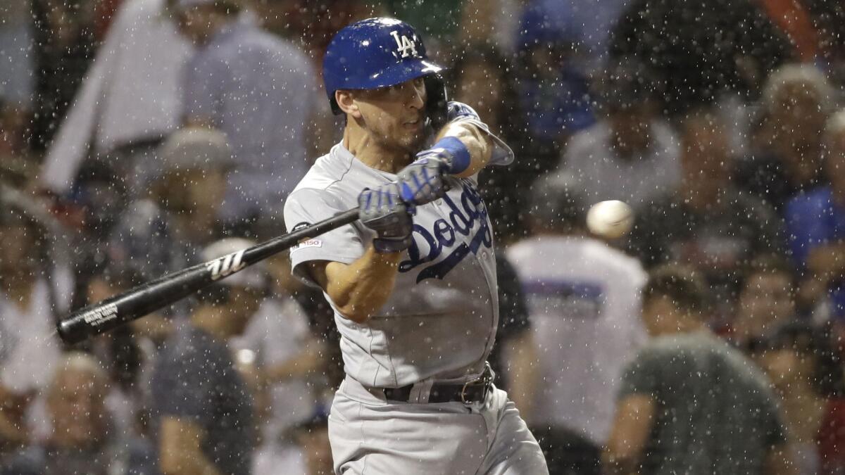 The Dodgers' Austin Barnes swings and misses against the Red Sox as rain comes down during the seventh inning Friday night at Fenway Park.