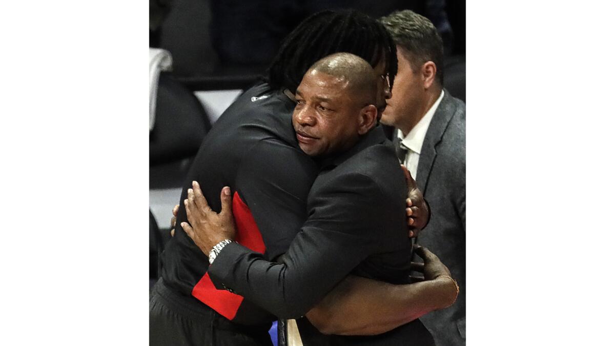 head coach Doc Rivers hugs center DeAndre Jordan after losing to the Lakers 100-115 in the final game of the season.