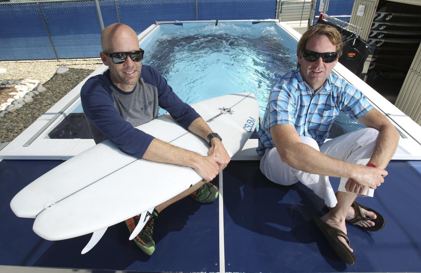Kinesiology professors, Assistant Professor Sean Newcomer, right, and Associate Professor Jeff Nessler, sit next to the swim flume where they and their students test subjects to collect scientific data that will improve surfboard and wetsuit designs.