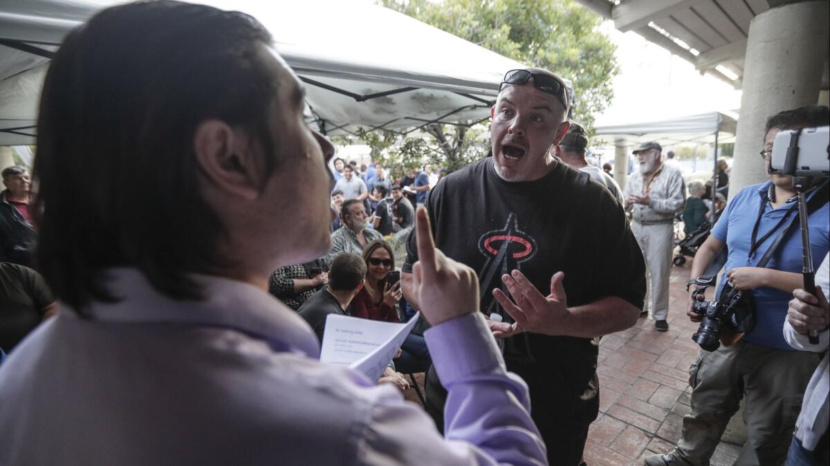 Paul Scott, left, argues against Los Alamitos' efforts to oppose California's sanctuary state policies with Joe Rodriguez before a City Council meeting.