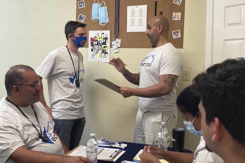 Alex Berrios, co-founder of the nonprofit Mi Vecino, coaches a new staff member as part of a Democratic outreach effort.