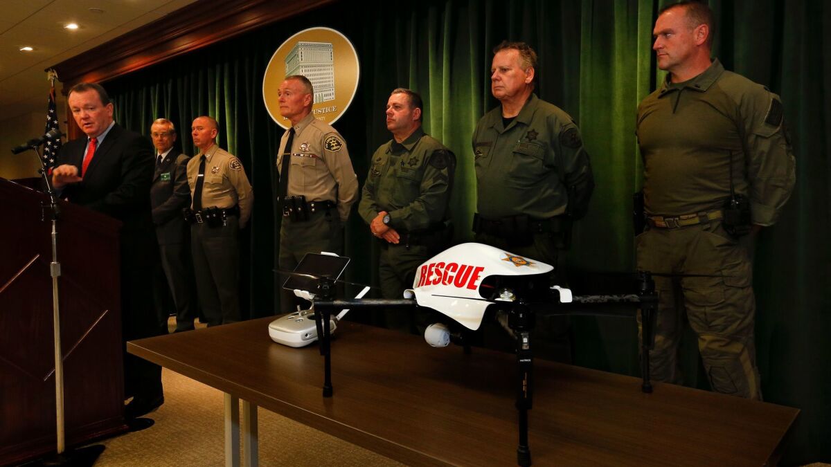 L.A. County Sheriff Jim McDonnell, left, announces early this year that his department plans to use drones to help deputies in search and rescue, bomb detection and more.