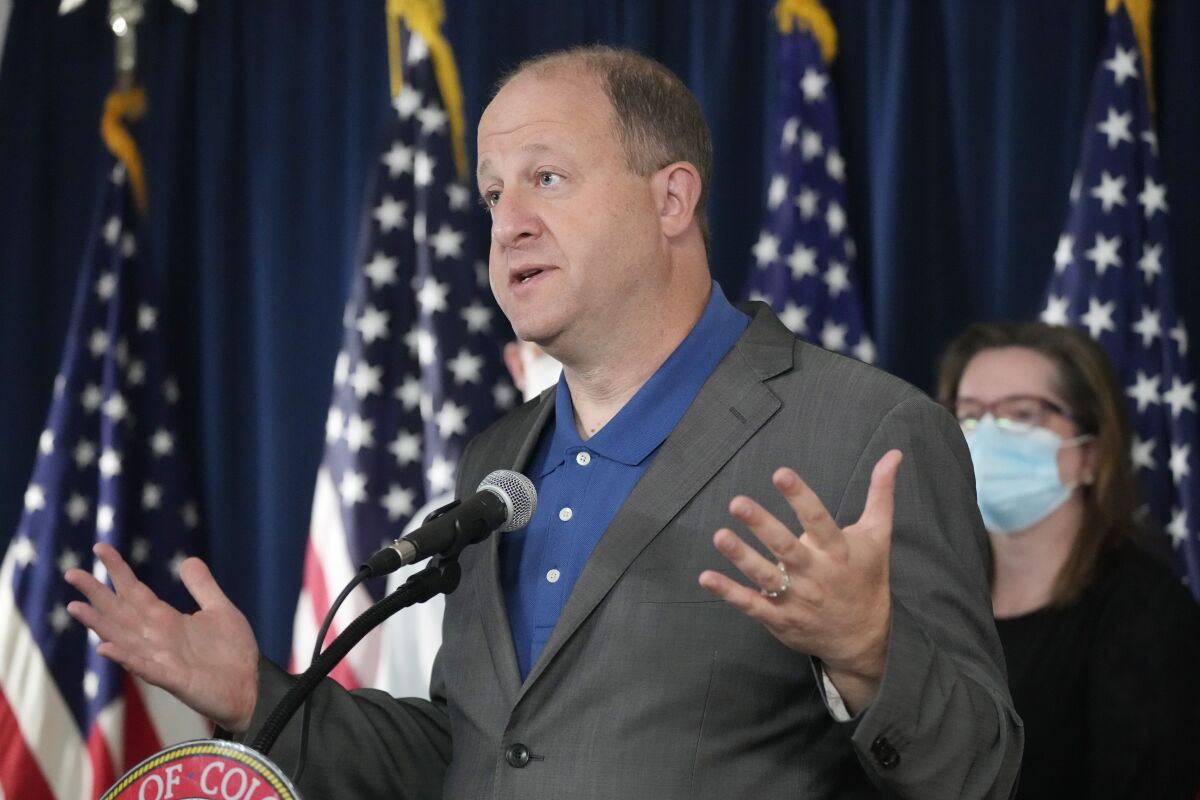 FILE - Colorado Gov. Jared Polis speaks during a news conference about Colorado offering coronavirus vaccinations to children, Thursday, Oct. 28, 2021, in Denver. Infection rates have soared in Colorado over the past month, and Polis signed an executive order on Thursday, Nov. 11, 2021, to expand the use of booster shots to quell the recent surge in COVID-19 infections. (AP Photo/David Zalubowski, File)
