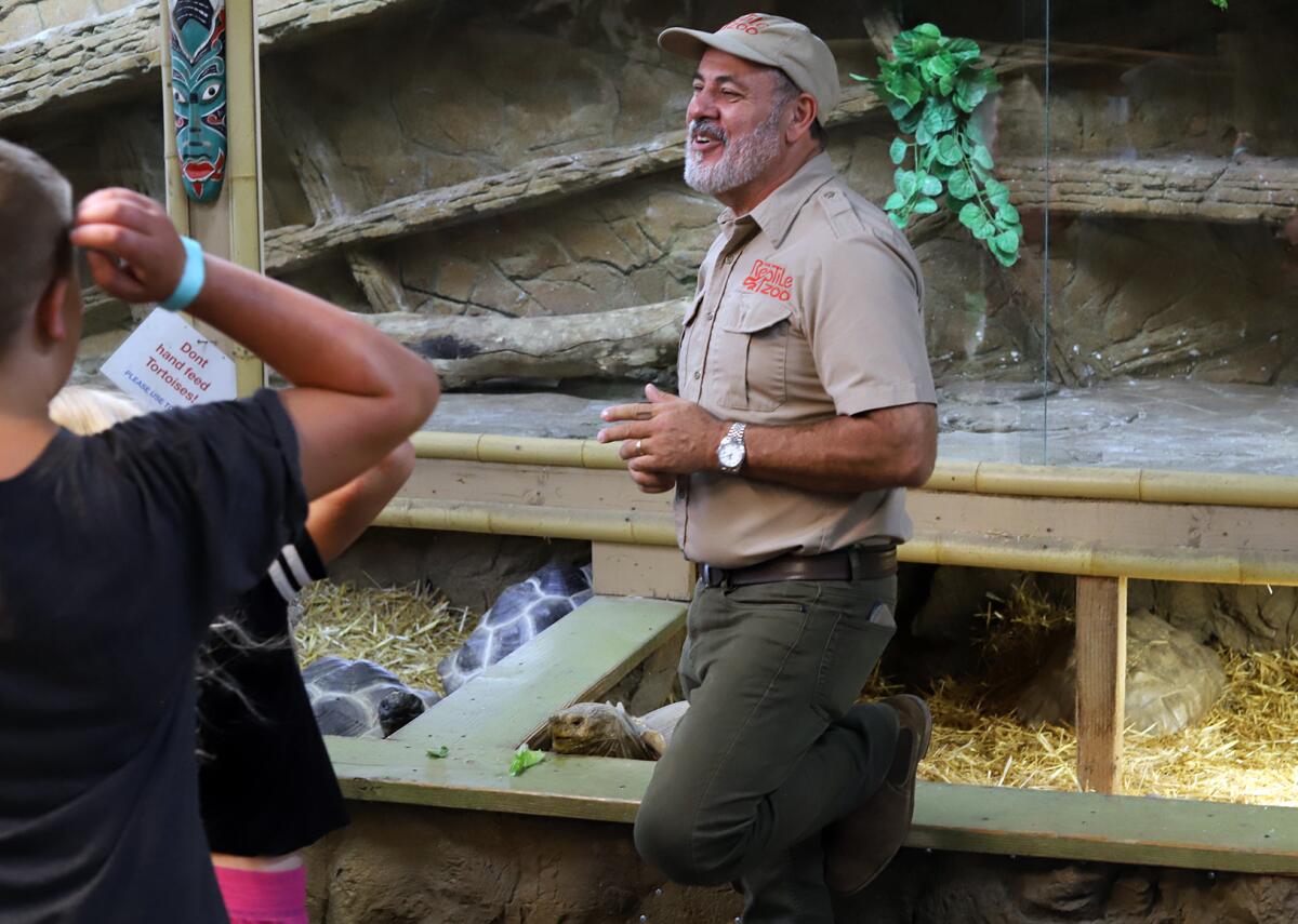 Jay Brewer, the founder of the Reptile Zoo, answers questions from visitors to the zoo on Monday.