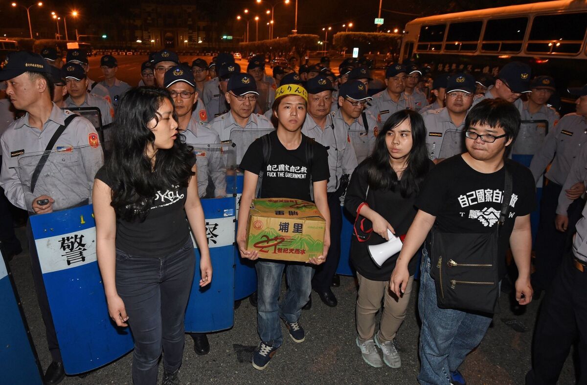 Pro-Taiwan independence protesters stand in front of riot police outside the presidential office in Taipei on April 1.