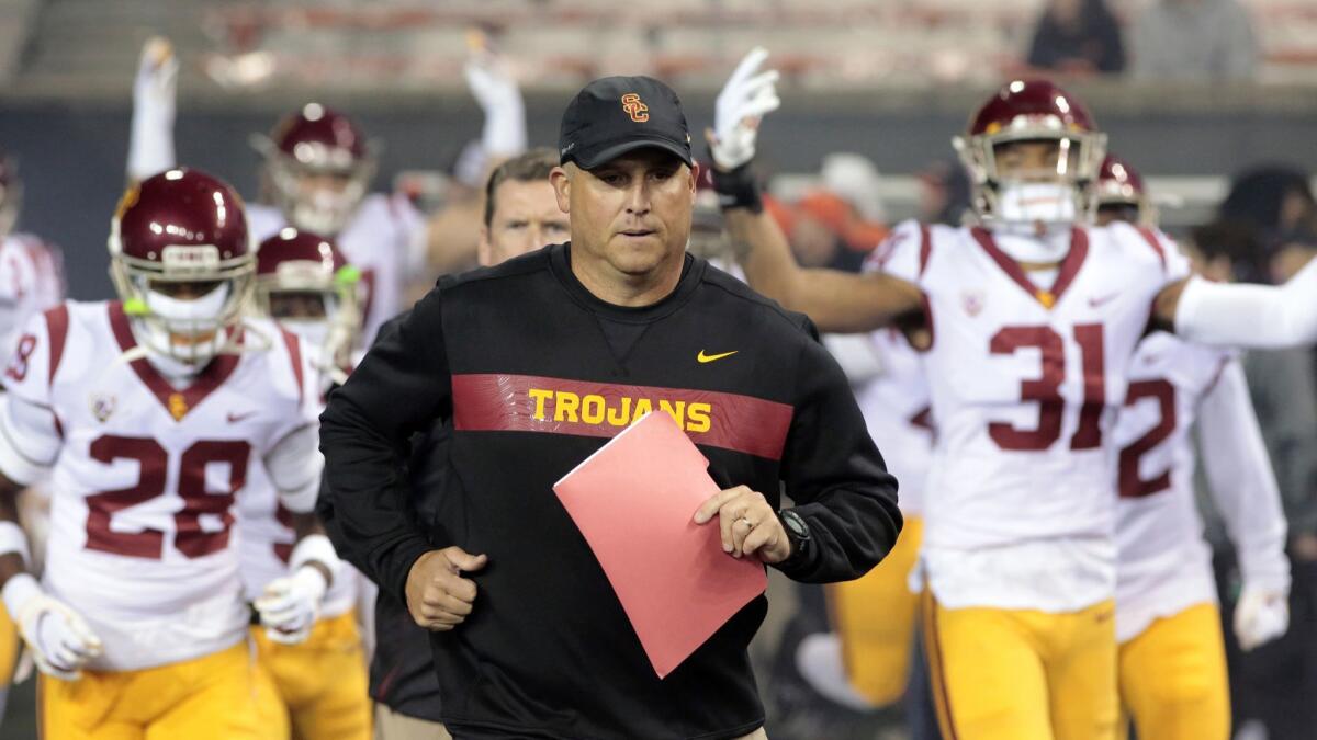 Clay Helton leads the Trojans onto the field last season.