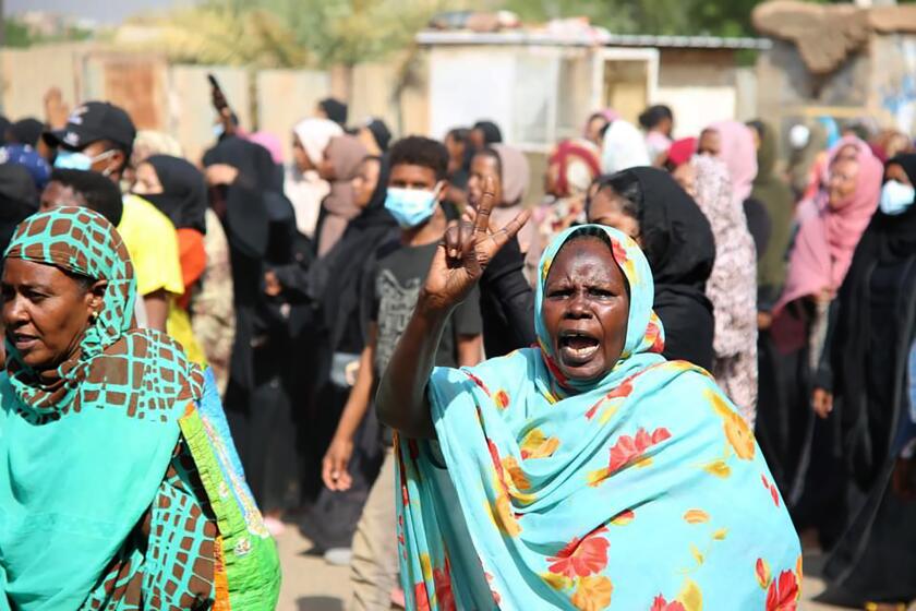 A pro-democracy protester flashes the victory sign as thousands take to the streets to condemn a takeover by military officials, in Khartoum, Sudan, Monday Oct. 25, 2021. Sudan’s military seized power Monday, dissolving the transitional government hours after troops arrested the acting prime minister and other officials. The takeover comes more than two years after protesters forced the ouster of longtime autocrat Omar al-Bashir and just weeks before the military was expected to hand the leadership of the council that runs the African country over to civilians. (AP Photo/Ashraf Idris)