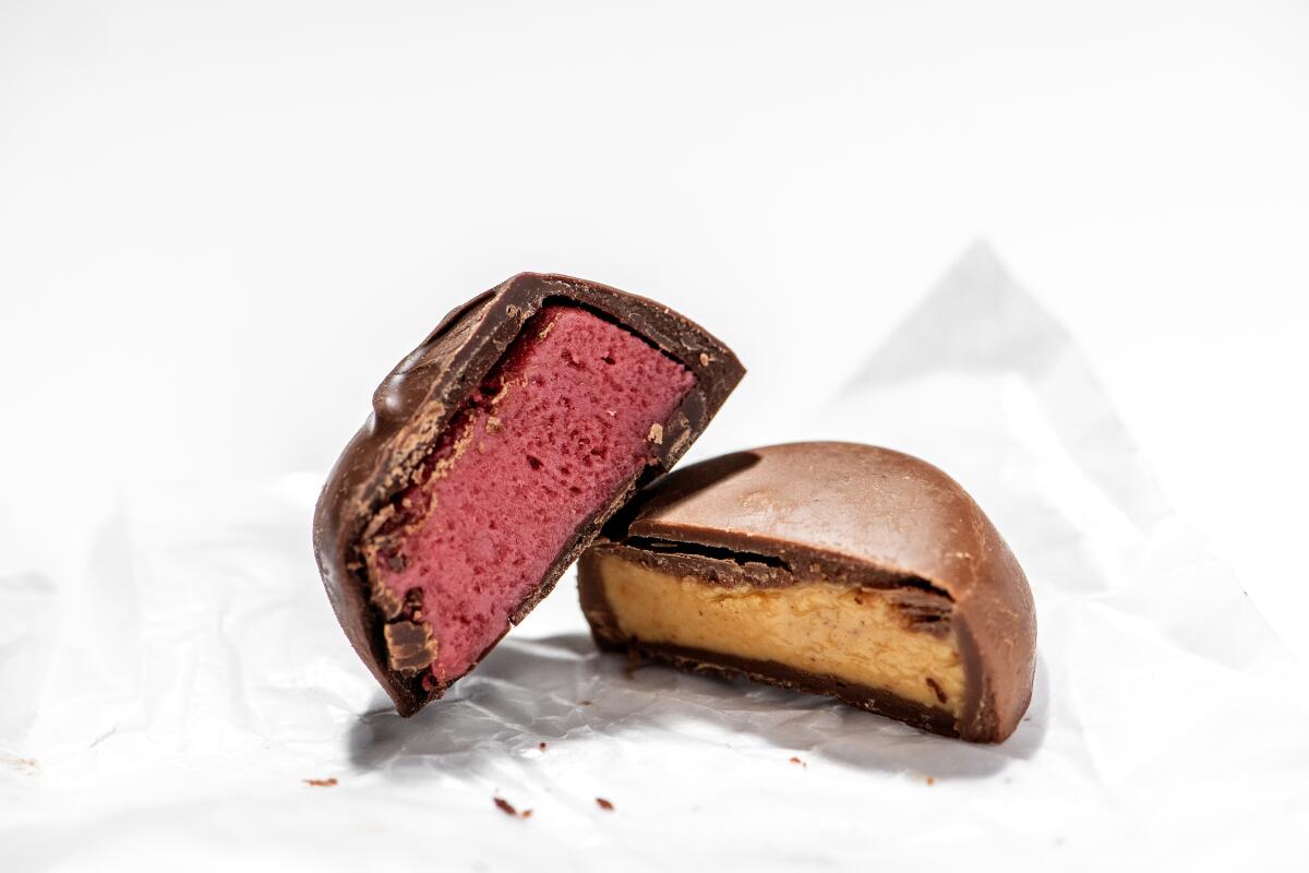 A See's Candies Raspberry Cream and a Peanut Butter Patty, each cut in half.