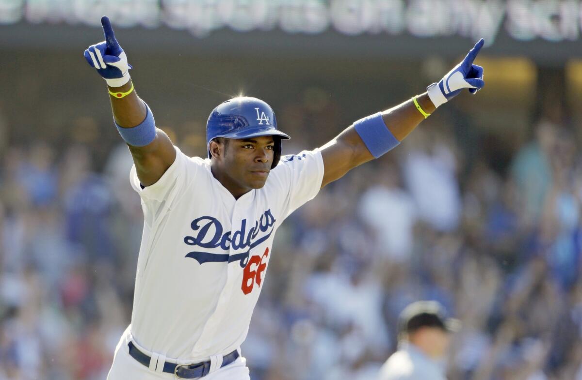Dodgers right fielder Yasiel Puig celebrates after hitting a walk-off home run in the 11th inning of the Dodgers' 1-0 victory over the Cincinnati Reds on Sunday.