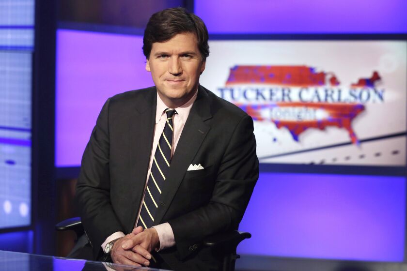 FILE - Tucker Carlson, host of "Tucker Carlson Tonight," poses for photos in a Fox News Channel studio on March 2, 2017, in New York. Carlson's belittling of a reporter for The New York Times this week for publicly discussing how she had been harassed reveals both a toxic online culture and bad blood between the newspaper, Fox News Channel and its most popular personality. (AP Photo/Richard Drew, File)