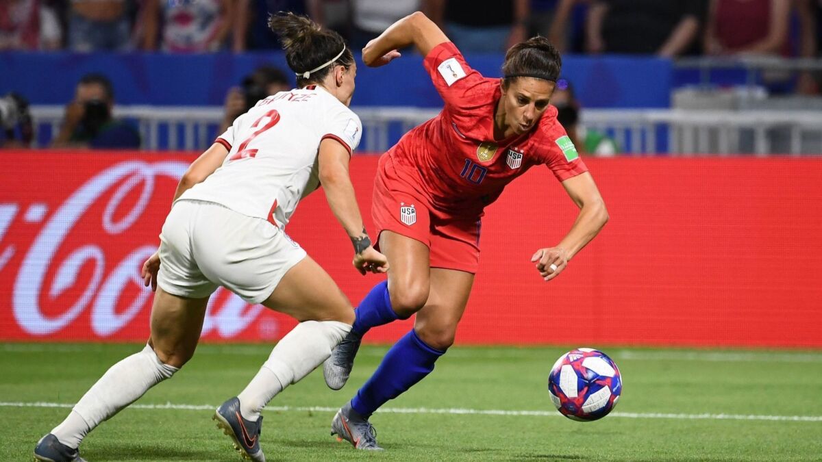 U.S. forward Carli Lloyd tries to maneuver around England defender Lucy Bronze during a Women's World Cup semifinal on Tuesday.