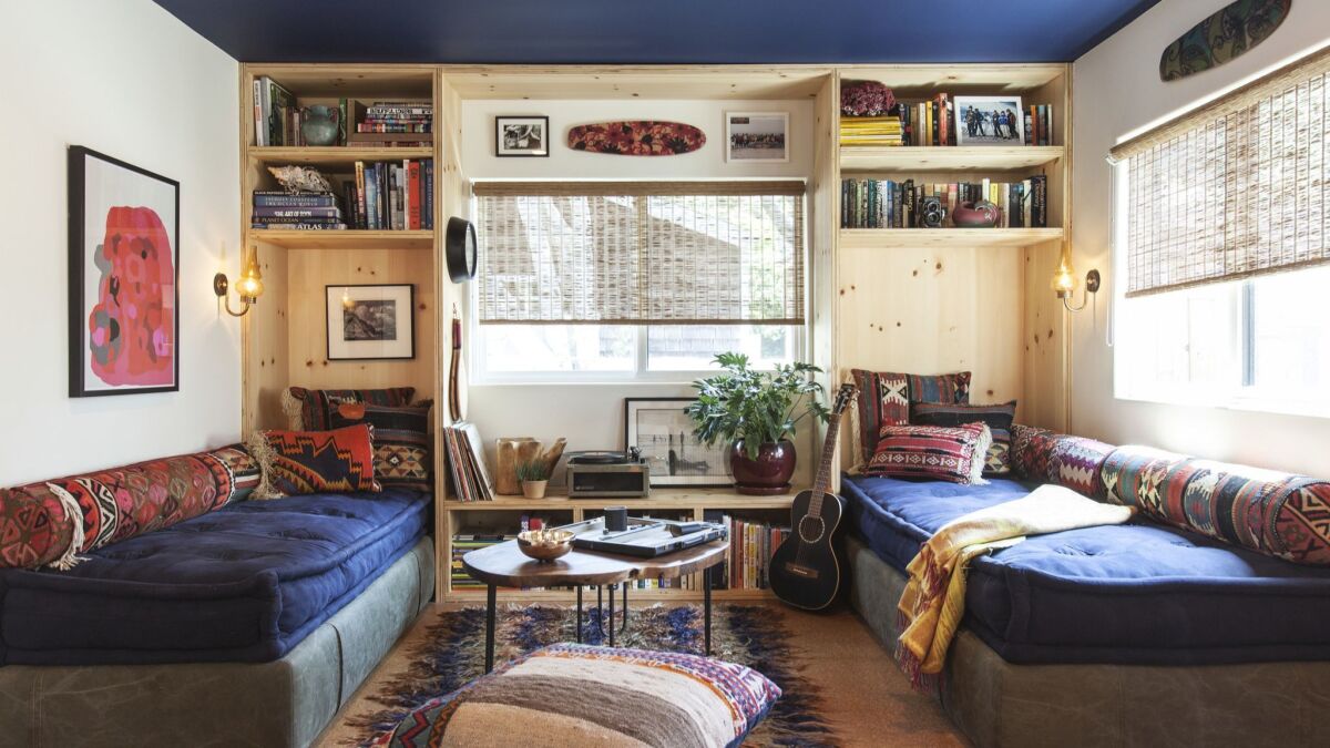 Commune Design renovated a mobile home in Malibu's Paradise Cove to include custom plywood bookshelves and reading nooks fitted with cozy daybeds.