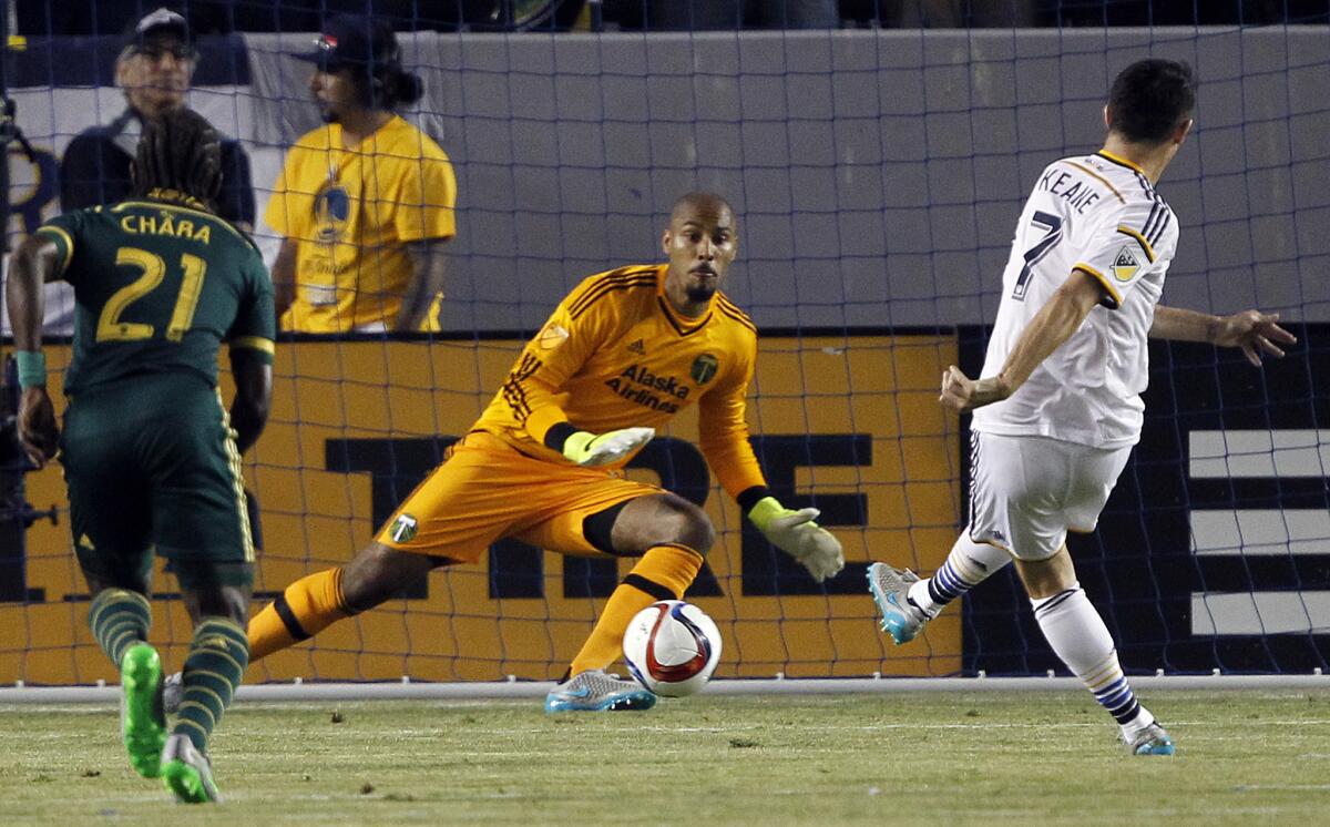 Los Angeles Galaxy forward Robbie Keane, right, scores on a penalty kick against Portland Timbers goalkeeper Adam Kwarasey, center, with midfielder Diego Chara (21) watching during the first half of an MLS soccer game in Carson, Calif., Wednesday, June 24, 2015. (AP Photo/Alex Gallardo)