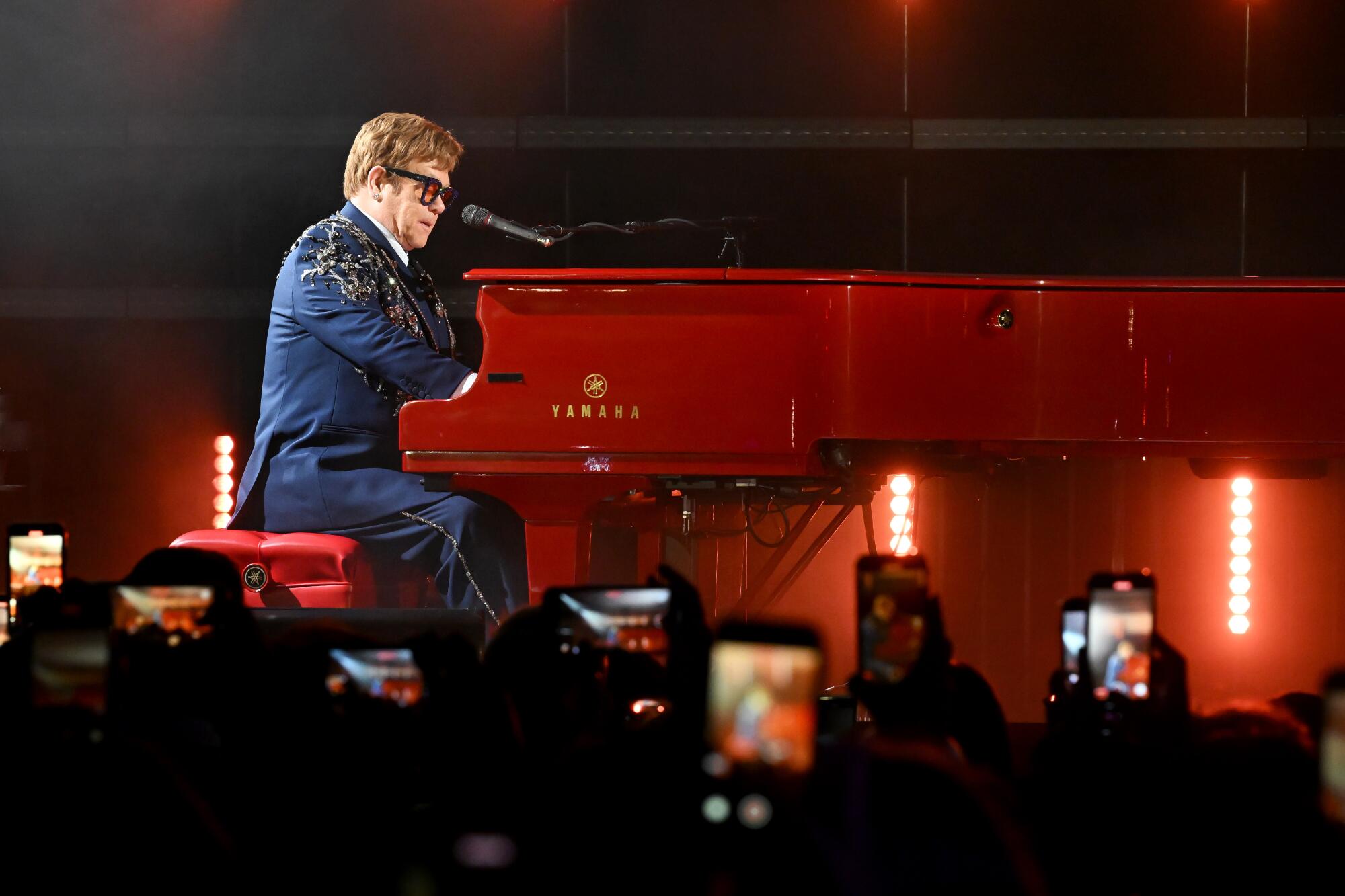 Elton John at a red piano