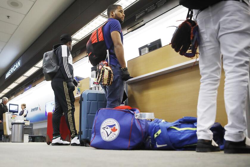 Toronto Blue Jays minor league baseball player Steward Berroa, center, prepares to fly home along with his teammates from the Dominican Republic at Tampa International Airport in Tampa, Fla. on Sunday, March 15, 2020. Flight schedules for departures and arrivals remain normal during the coronavirus pandemic. (Octavio Jones/Tampa Bay Times/TNS) ** OUTS - ELSENT, FPG, TCN - OUTS **