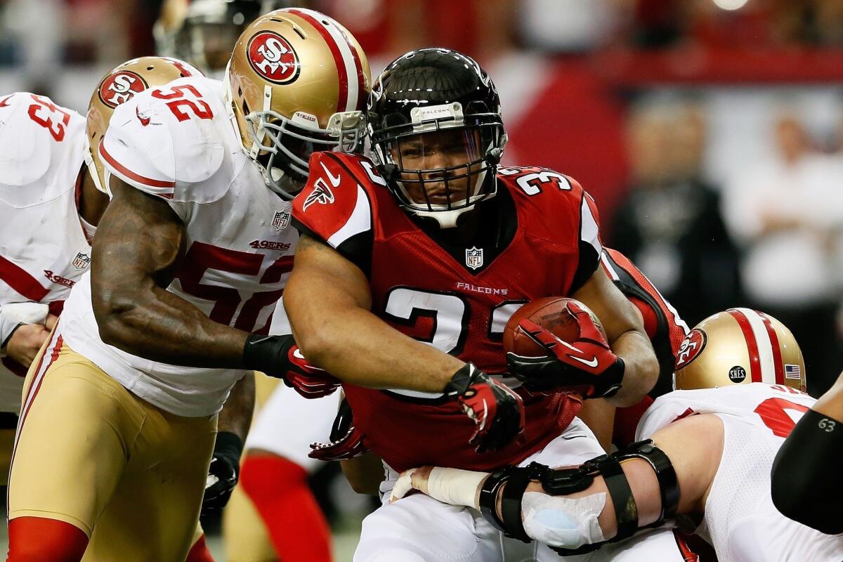 Falcons running back Michael Turner is brought down by 49ers linebacker Patrick Willis after a short gain in the NFC championship game.