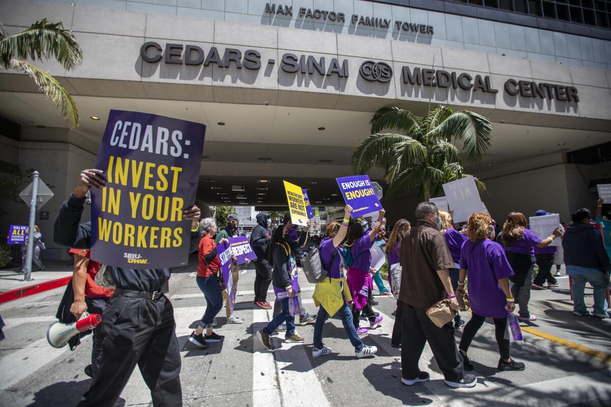 Union members hold signs during protest outside a hospital in Los Angeles.