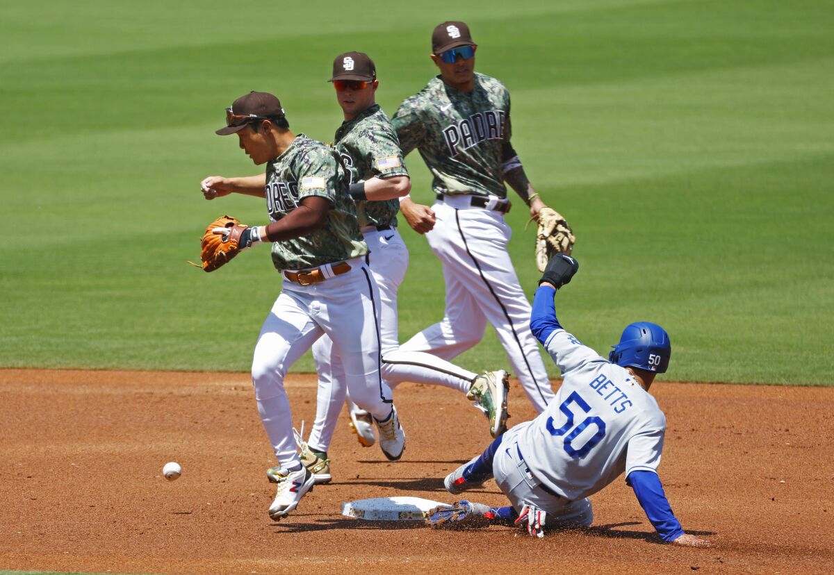 Padres shortstop Ha-seong Kim, left, can't hang on to a flipped ball by Manny Machado