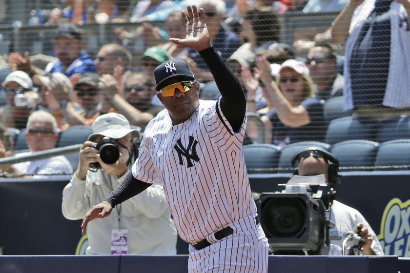 Former New York Yankee Marcus Thames waves as he is introduced during Old Timer's Day at Yankee Stadium.
