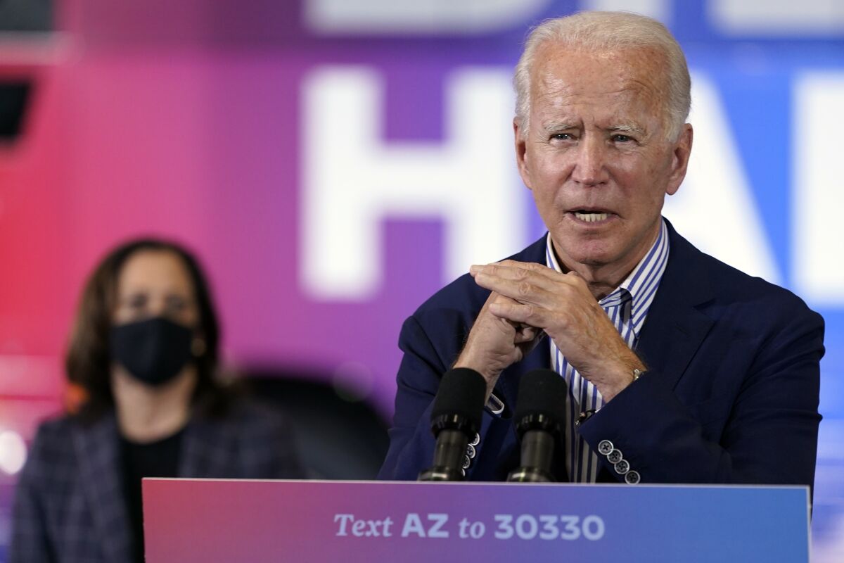 Former Vice President Joe Biden speaks as Sen. Kamala Harris listens at an event in Phoenix
