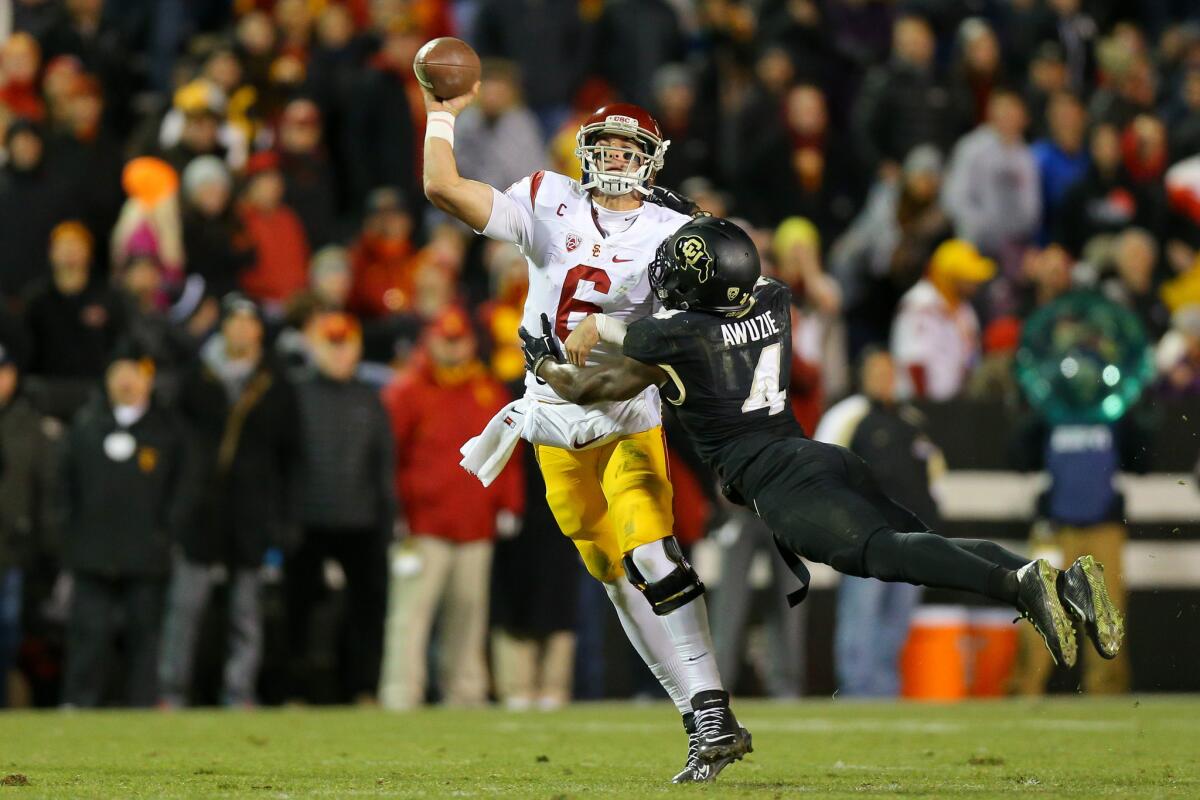 USC quarterback Cody Kessler is hit by Colorado defensive back Chidobe Awuzie as he throws a pass in the third quarter Saturday.