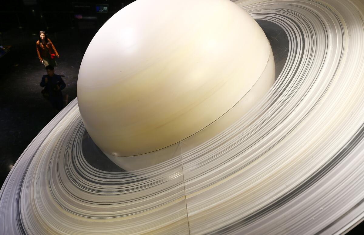 Visitors walk through a display of the solar system in the lower level 