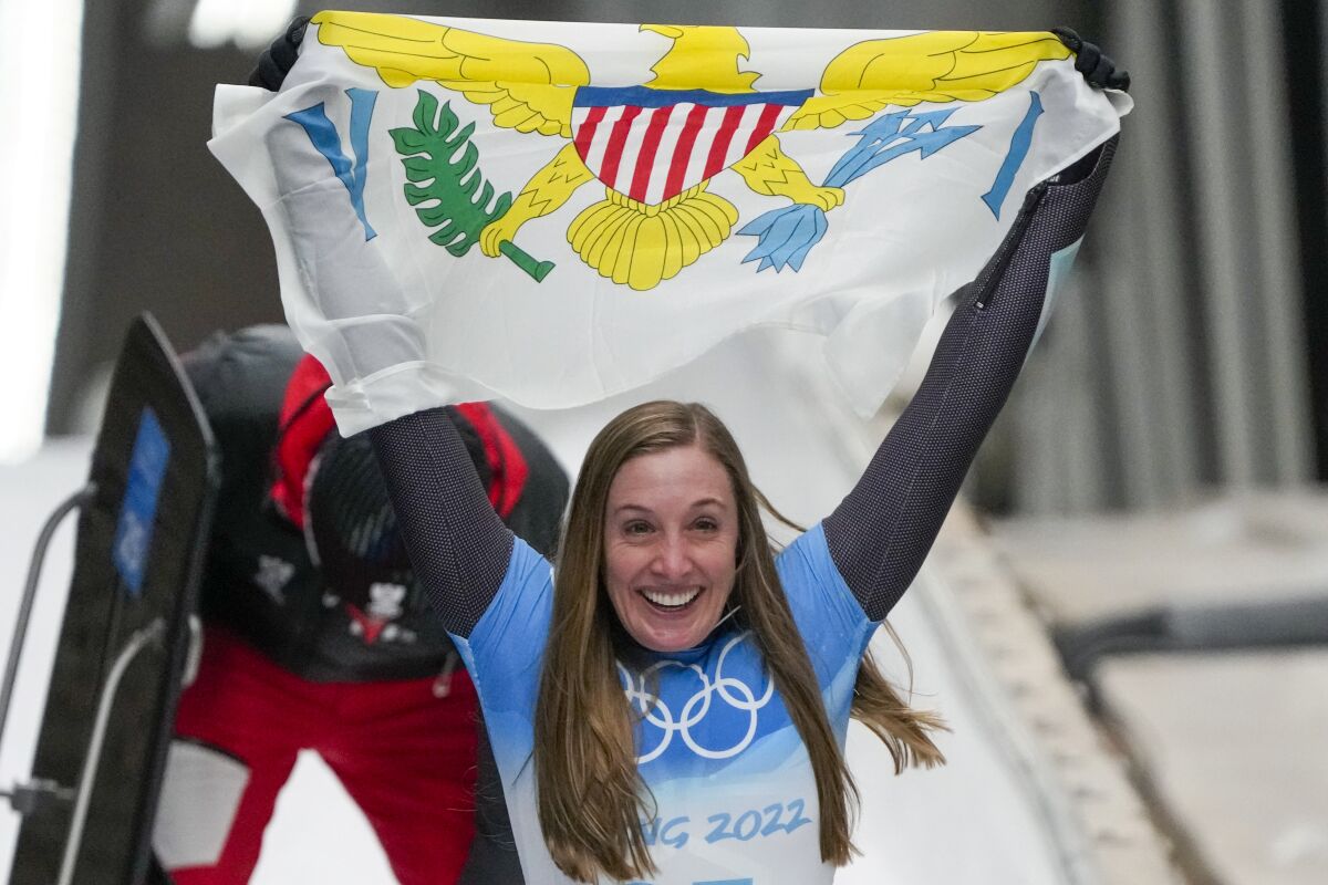 Katie Tannenbaum, of Virgin Islands, celebrates after the women's skeleton run 3 at the 2022 Winter Olympics, Saturday, Feb. 12, 2022, in the Yanqing district of Beijing. (AP Photo/Mark Schiefelbein)
