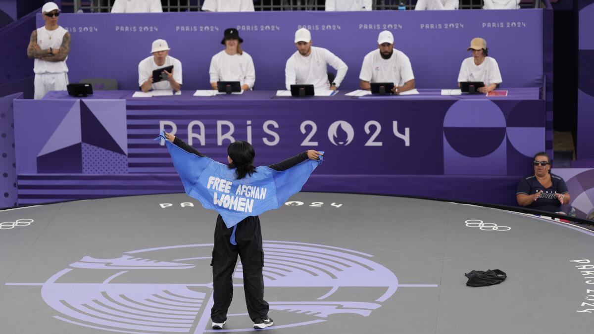 Manizha Talash wears a cape which reads "free Afghan women" as she competes in qualifying.