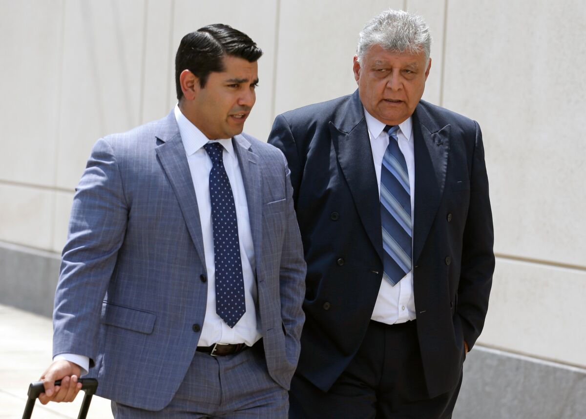 Pedro Pablo Barrientos, right, leaves federal court in Orlando, Fla., Monday with his attorney, Luis Calderon.