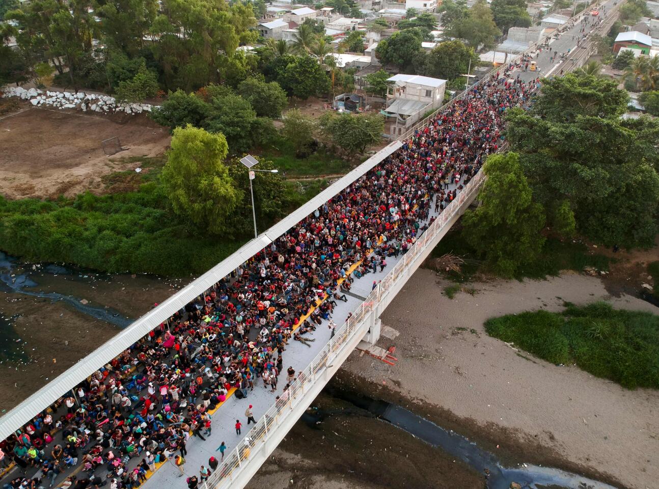 Central American migrants, mostly Hondurans, traveling in a caravan to the U.S., remain at the international bridge that connects Tecum Uman, Guatemala, with Ciudad Hidalgo, Mexico.