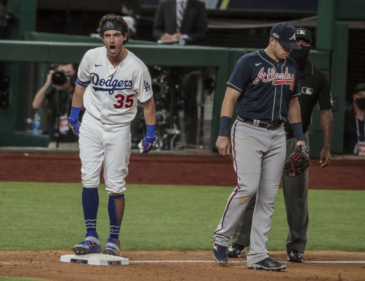 Dodgers center fielder Cody Bellinger yells, "Let's go!" to teammates after hitting an RBI triple.