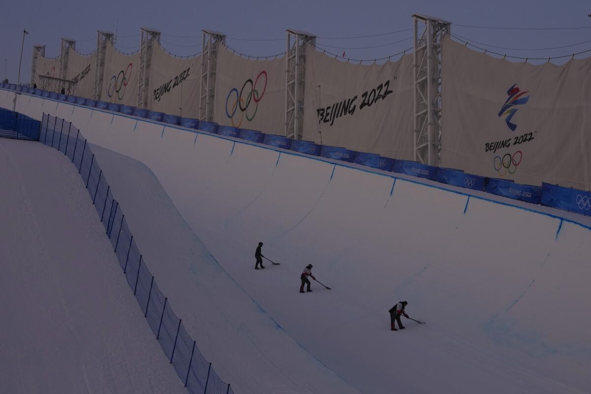 Workers prepare the halfpipe course at Genting Snow Park before the women's halfpipe finals.