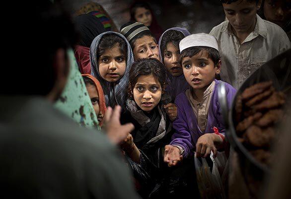 Pakistani children at a food distribution site in Rawalpindi ask for a share.