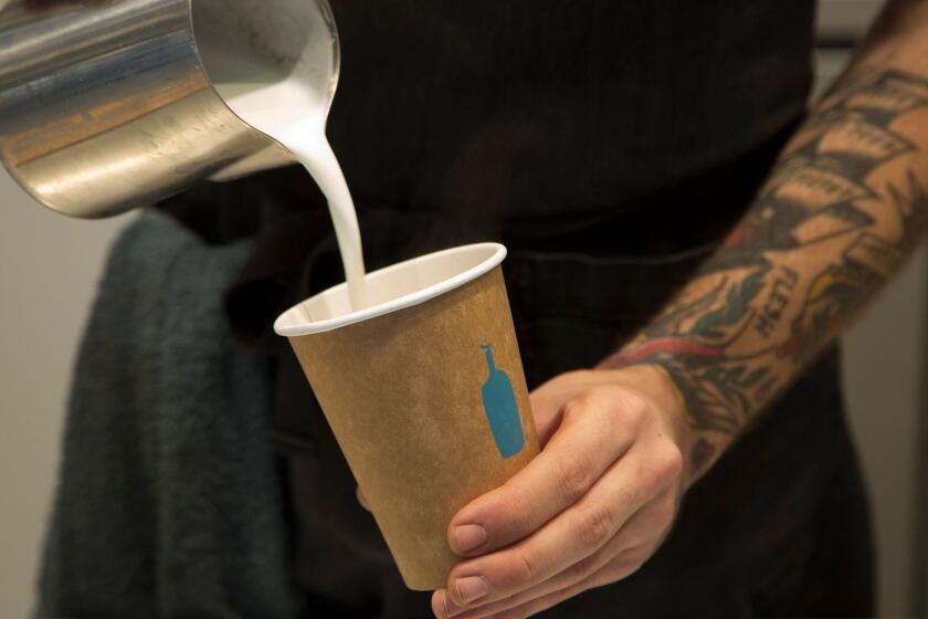 LOS ANGELES, CA. -- FEBRUARY 10, 2017: A server pours a cappuccino at Blue Bottle in downtown Los Angeles. The store's bookshelves are filled with books for sale with going to the Library Foundation of Los Angeles. (Myung J. Chun / Los Angeles Times)