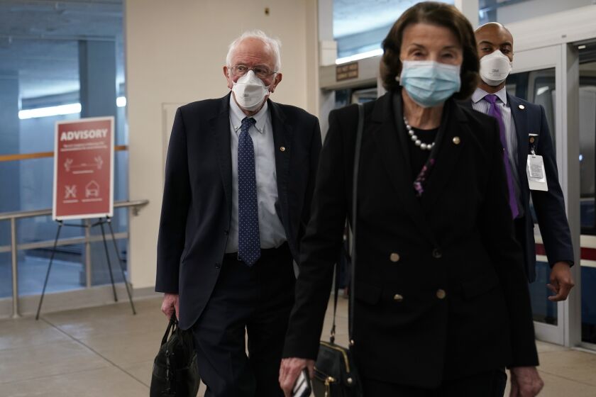 Sen. Bernie Sanders, I-Vt., left, follows Sen. Dianne Feinstein, D-Calif., right, as they arrive for the second impeachment trial of former President Donald Trump on Capitol in Washington, Tuesday, Feb. 9, 2021. (AP Photo/Susan Walsh)