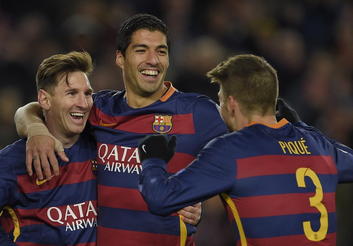Barcelona's defender Gerard Pique (R) celebrates with Barcelona's Argentinian forward Lionel Messi (L) and Barcelona's Uruguayan forward Luis Suarez after scoring during the UEFA Champions League Group E football match FC Barcelona vs AS Roma at the Camp Nou stadium in Barcelona on November 24, 2015.
