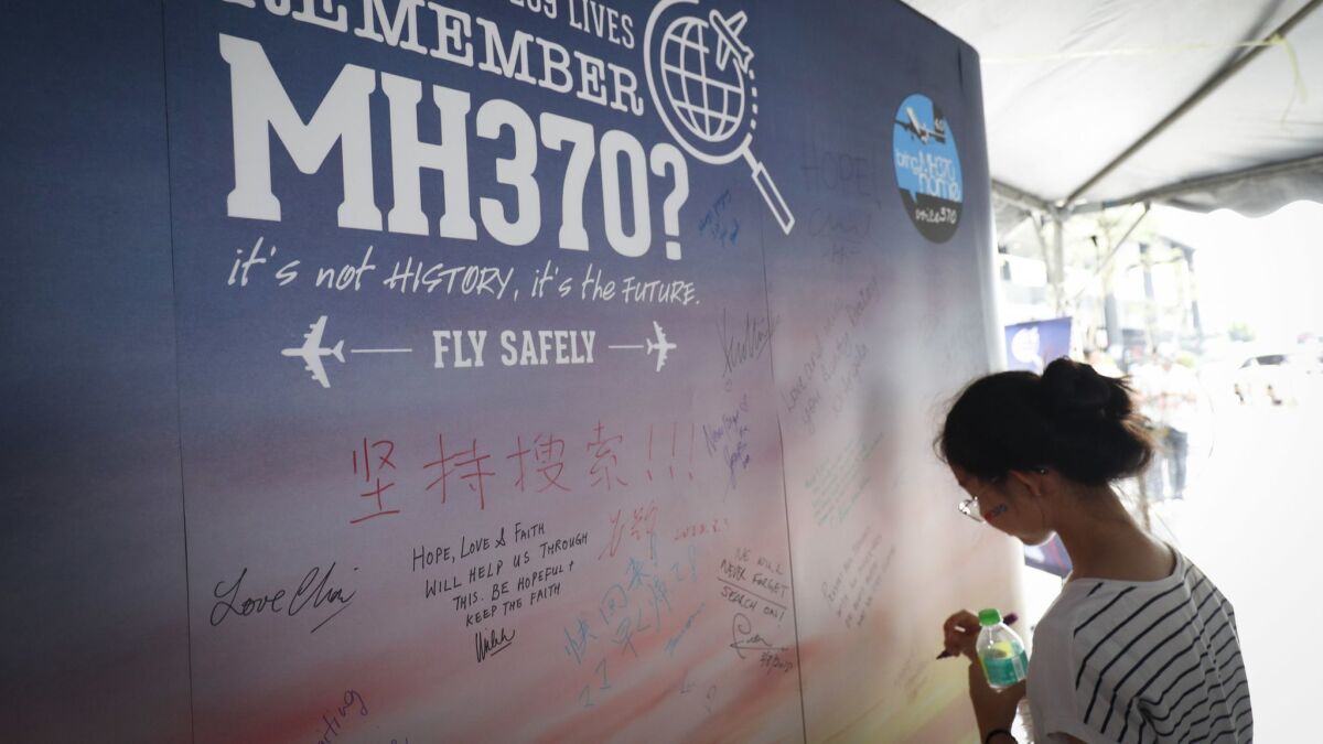 A girl writes a condolence message during the Day of Remembrance for missing MH370 plane event in Kuala Lumpur, Malaysia, on March 3.