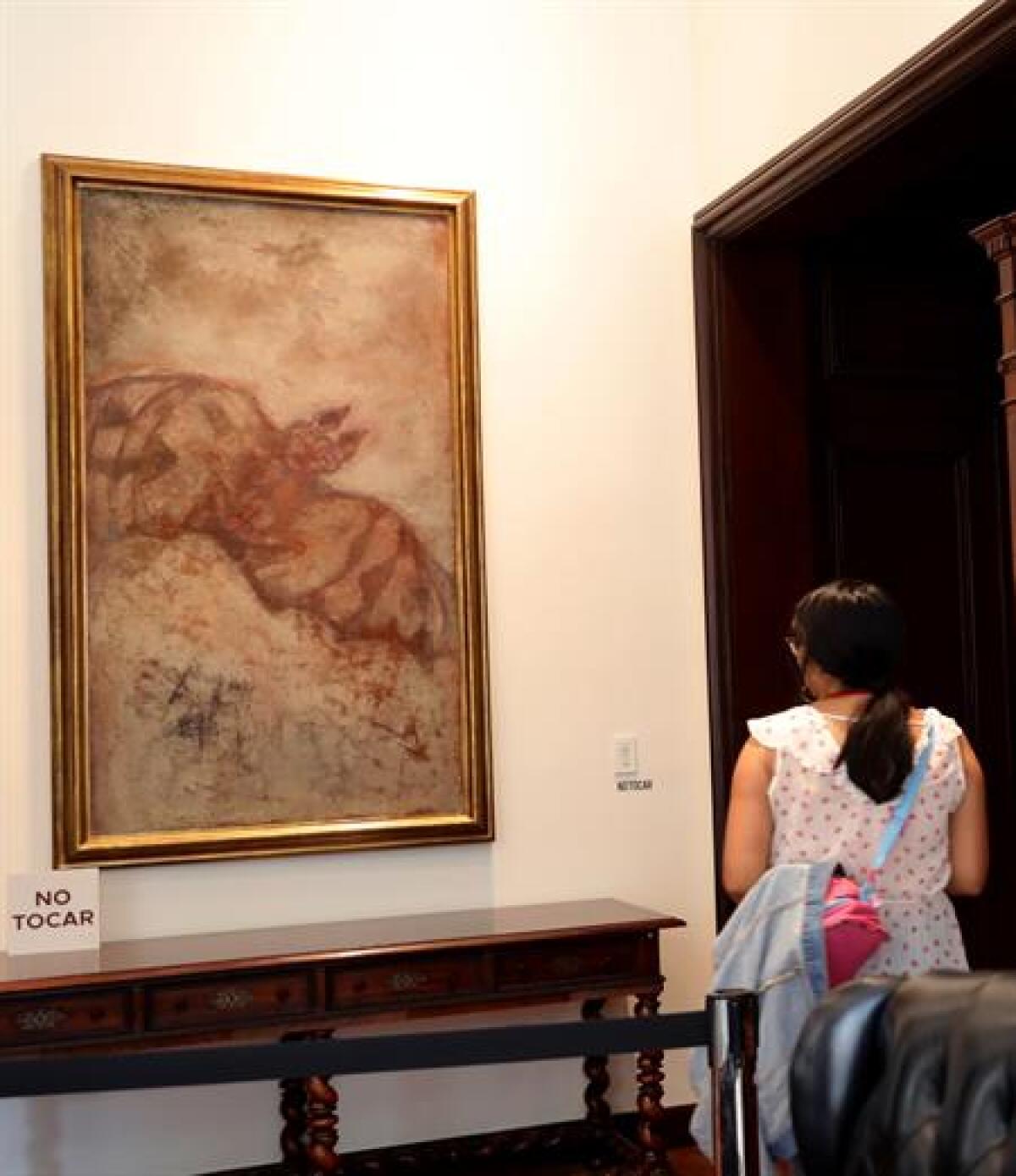 Una mujer observa la obra Murciélago del pintor mexicano Francisco Toledo dentro del recorrido de la exposición "De lo perdido, lo que aparezca. 33 visiones de la pintura en México", en Ciudad de México.