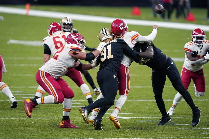 Kansas City Chiefs quarterback Patrick Mahomes (15) fumbles as he is sacked by New Orleans Saints defensive end Trey Hendrickson (91) in the second half of an NFL football game in New Orleans, Sunday, Dec. 20, 2020. (AP Photo/Butch Dill)
