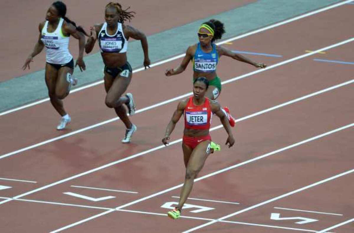 Carmelita Jeter crosses the finish line first in her 100-meter semifinal race.