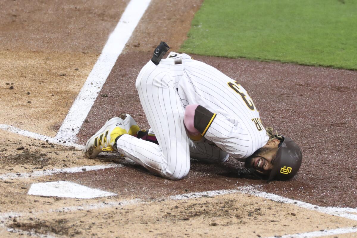 San Diego Padres' Fernando Tatis Jr. reacts after hurting his shoulder while swinging at a pitch in the third inning of a baseball game against the San Francisco Giants, Monday, April 5, 2021, in San Diego. (AP Photo/Derrick Tuskan)