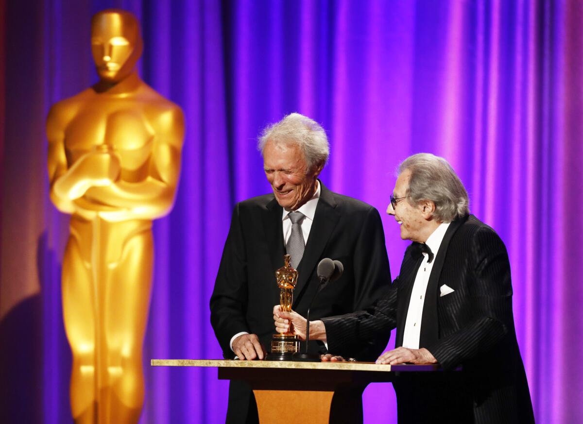 Clint Eastwood, left, presents composer Lalo Schifrin with his Oscar.