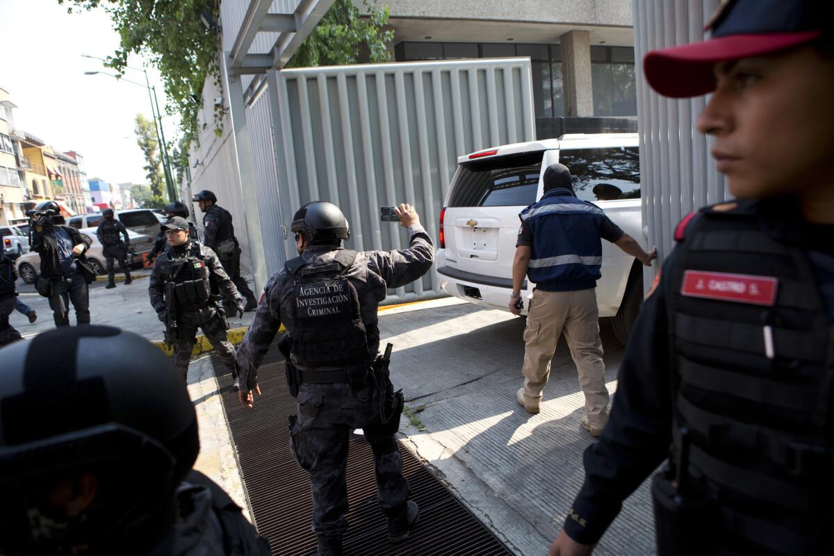 Security agents stand guard as a vehicle carrying Damaso Lopez, nicknamed "El Licenciado," arrives at the attorney general's office for organized crime in Mexico City, Tuesday, May 2, 2017. Mexican prosecutors said they captured Lopez, one of the Sinaloa cartel leaders who launched a struggle for control of the gang following the re-arrest of Joaquin "El Chapo" Guzman. Lopez was long considered Guzman's right-hand man and helped him escape from a Mexican prison in 2001. (AP Photo/Rebecca Blackwell)