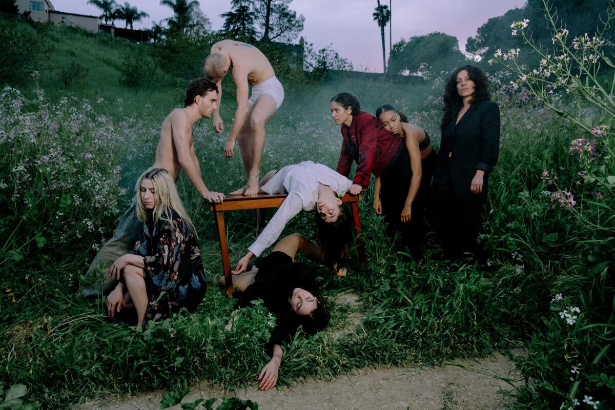 Men (some nearly naked) and women frolick in the park.