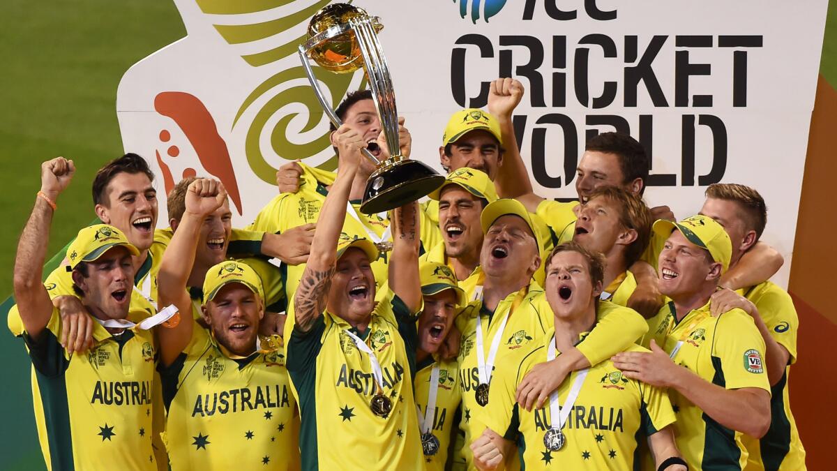 Australian captain Michael Clarke holds the winner's trophy as he celebrates with his teammates following their victory over New Zealand in the cricket World Cup final on Sunday.