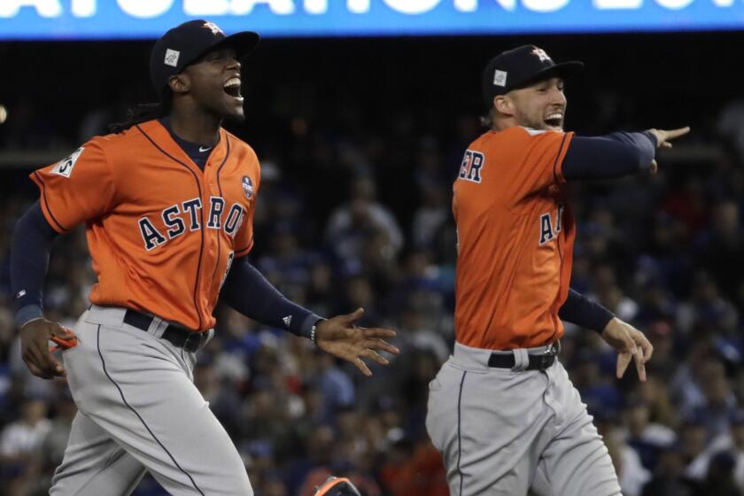 Astros outfielders George Springer, right, and Cameron Maybin run in to celebrate with teammates after beating the Dodgers 5-1 in Game 7 of the 2017 World Series.