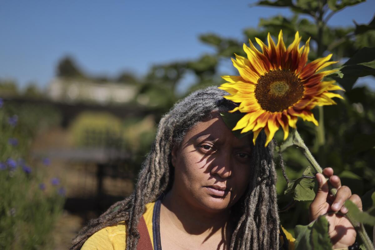 Doria Robinson holds a sunflower bloom. 