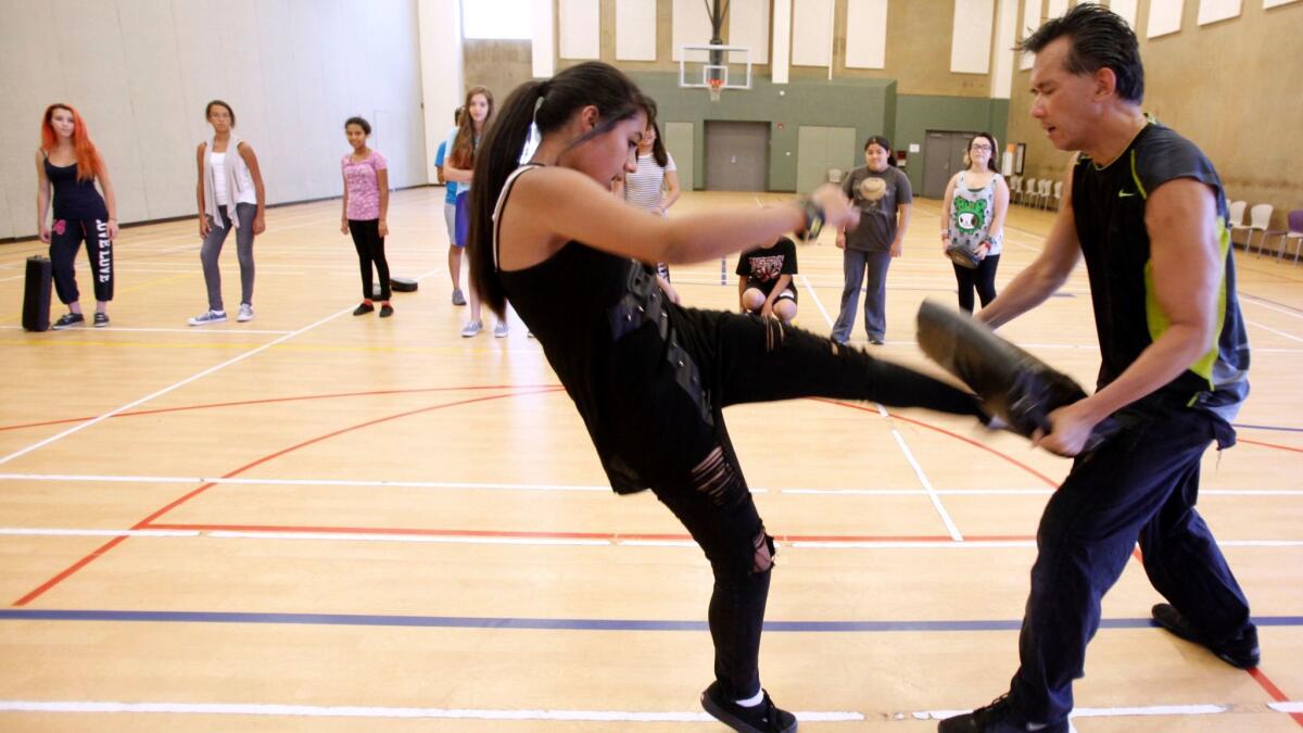 Alexandria Meneses, of Burbank, learns self-defense techniques from instructor Nelson Nio at Pacific Community Center in Glendale as part of Camp Rosie in 2013.