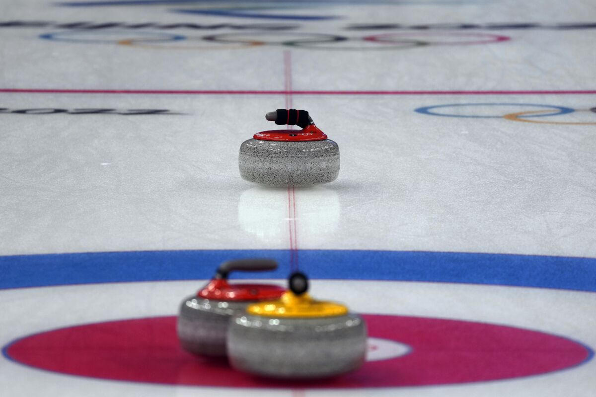 A curling stone moves on the ice during the mixed doubles curling match between Italy and Norway, at the 2022 Winter Olympics, Friday, Feb. 4, 2022, in Beijing.