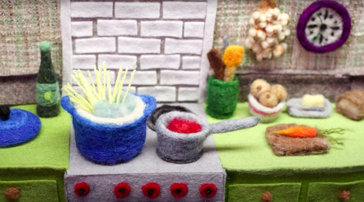 Screenshot from a colorful stop-motion video of cooking a pasta meal made from wool on Andrea Love's YouTube channel.